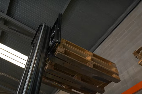 trabajador en almacen cargando cajas.