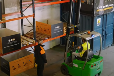 profesor enseñando en la clase práctica cómo funciona la carretilla elevadoras.